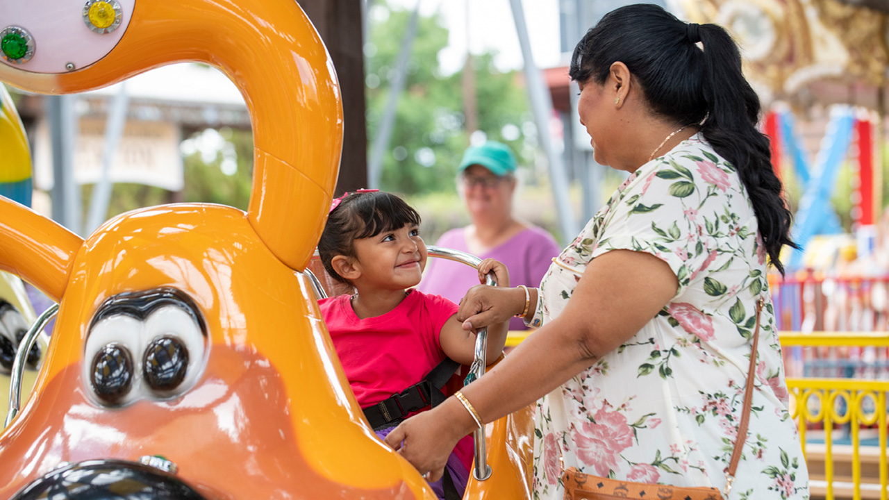 Un niño a punto de montar en el Doggie-Go-Round